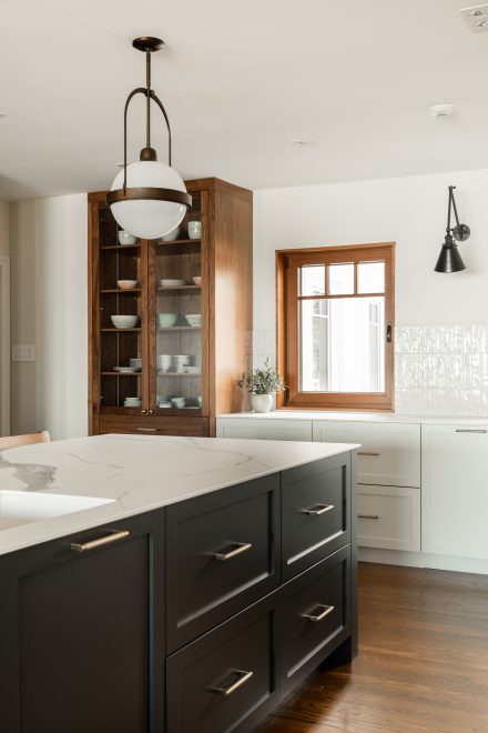 Bright white kitchen with a large island and abundant integrated storage space.