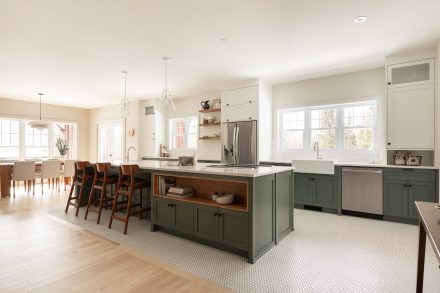 White kitchen with green cabinets and a large island