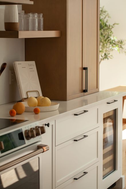 Une cuisine farmhouse avec îlot central en bois et des armoires blanches.