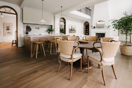 Cuisine lumineuse avec îlot en bois, comptoir en pierre claire et salle à manger intégrée, réalisée par Ateliers Jacob.