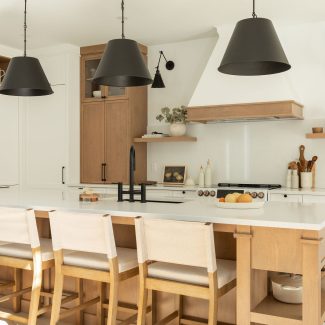 Une cuisine de style farmhouse avec un îlot central en bois et des armoires blanches.