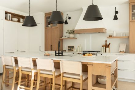 Une cuisine de style farmhouse avec un îlot central en bois et des armoires blanches.