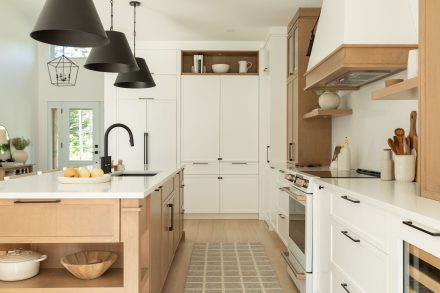 Une cuisine de style farmhouse avec un îlot central en bois et des armoires blanches. 