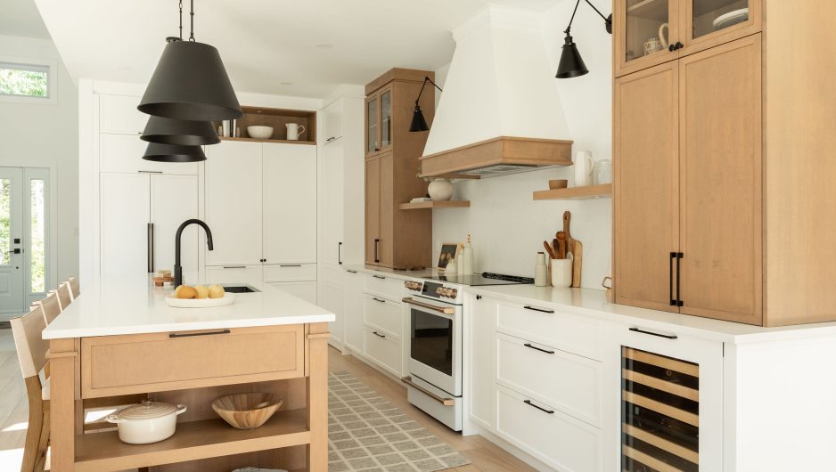 Une cuisine farmhouse avec îlot central en bois et des armoires blanches.