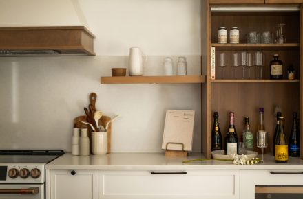 Une cuisine farmhouse avec îlot central en bois et des armoires blanches.