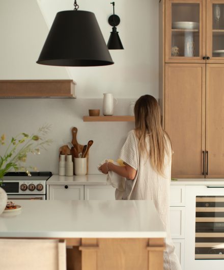 Une cuisine farmhouse avec îlot central en bois et des armoires blanches.