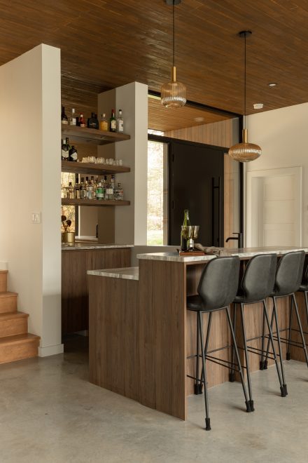 Kitchen designed by Ateliers Jacob with custom cabinets in wood and bar corner