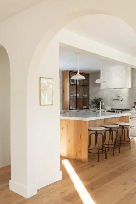 California inspired kitchen design made by Ateliers Jacob with a kitchen island, floating shelves in oak.