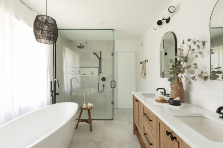 Bathroom with a bath, shower and wooden vanity in neutral tones