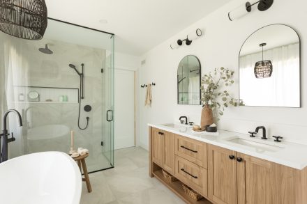 Bathroom with a bath, shower and wooden vanity in neutral tones