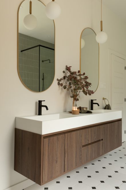 Custom made vanity with dark wood, and oval mirrors