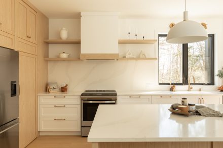 Kitchen with an island with seated places and windows facing the forest.