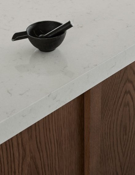 Architect-designed house in concrete with a bespoke wooden kitchen in dark oak from Nordiska Kok. Scandinavian minimalist interior design with concrete walls and floors. A modern home with smart hidden storage solutions and a beautiful site-built wooden bookshelf.