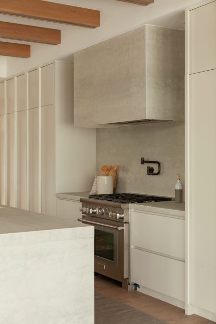 Alliant porcelaine aux textures minérales, hotte encastrée et armoires sans poignées, cette cuisine minimaliste révèle toute la sensibilité du style Japandi. Une réalisation signée Ateliers Jacob.