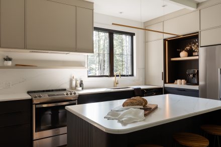 Cuisine sur mesure signée Ateliers Jacob avec comptoir en surface claire effet marbre, îlot central arrondi et dosseret assorti, idéale pour explorer les options de matériaux de comptoir.

