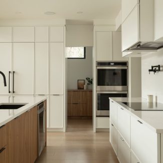 Une cuisine contemporaine conçu par Ateliers Jacob avec des armoires blanches et un ilot en bois clair