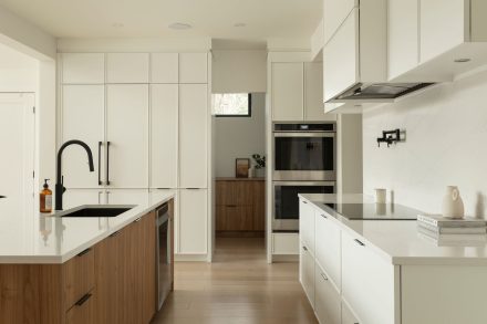 Une cuisine contemporaine conçu par Ateliers Jacob avec des armoires blanches et un ilot en bois clair