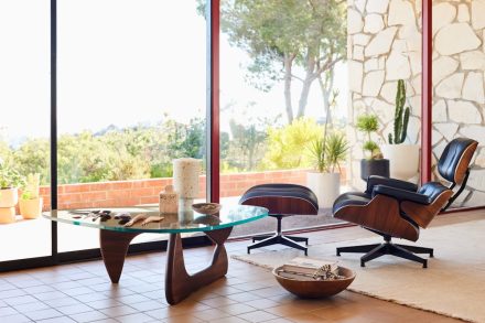 Icône du design mid-century moderne, la chaise Eames Lounge Chair and Ottoman en noyer trône dans un salon baigné de lumière.