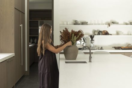 Cuisine Ateliers Jacob avec îlot clair, bois naturel et bouquet végétal, illustrant les tendances couleurs 2026 inspirées de la nature.