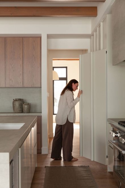 Réfrigérateur encastré dans la cuisine Farand, intégré dans les façades pleine hauteur pour préserver la continuité des lignes.