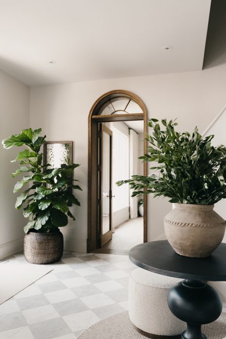 Dans l’entrée, le végétal marque la transition entre les pièces, posé au sol ou sur la table, comme une présence vivante qui structure l’espace et le relie doucement à l’extérieur.