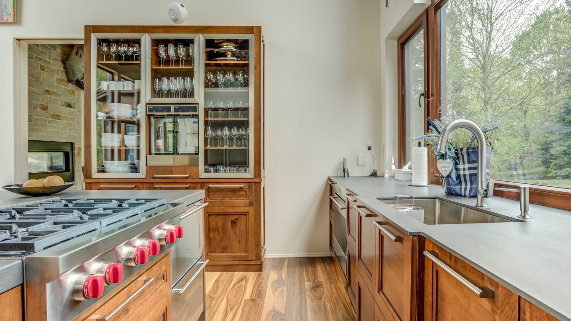 Cuisine contemporaine comprenant une haute armoire en érable. Une partie des portes de cette armoires sont vitrées.