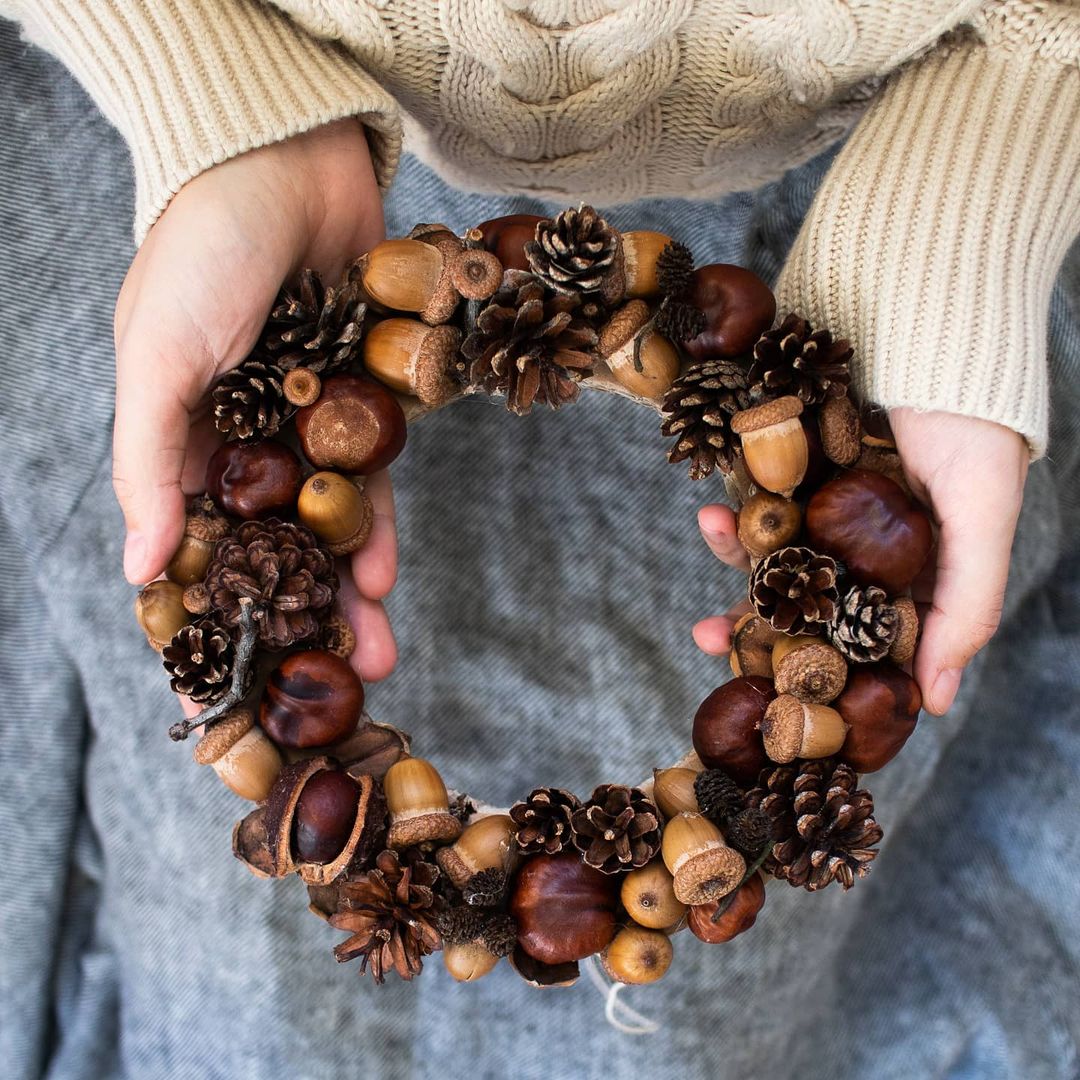 Couronne automnale faite de marrons, glands et autres éléments de la forêt.