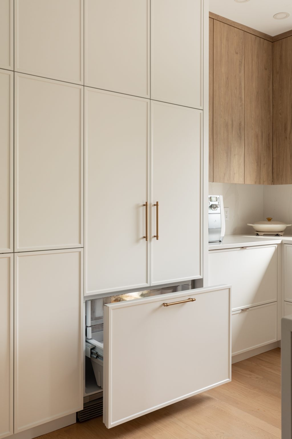 White and oak kitchen cabinets with concealed fridge