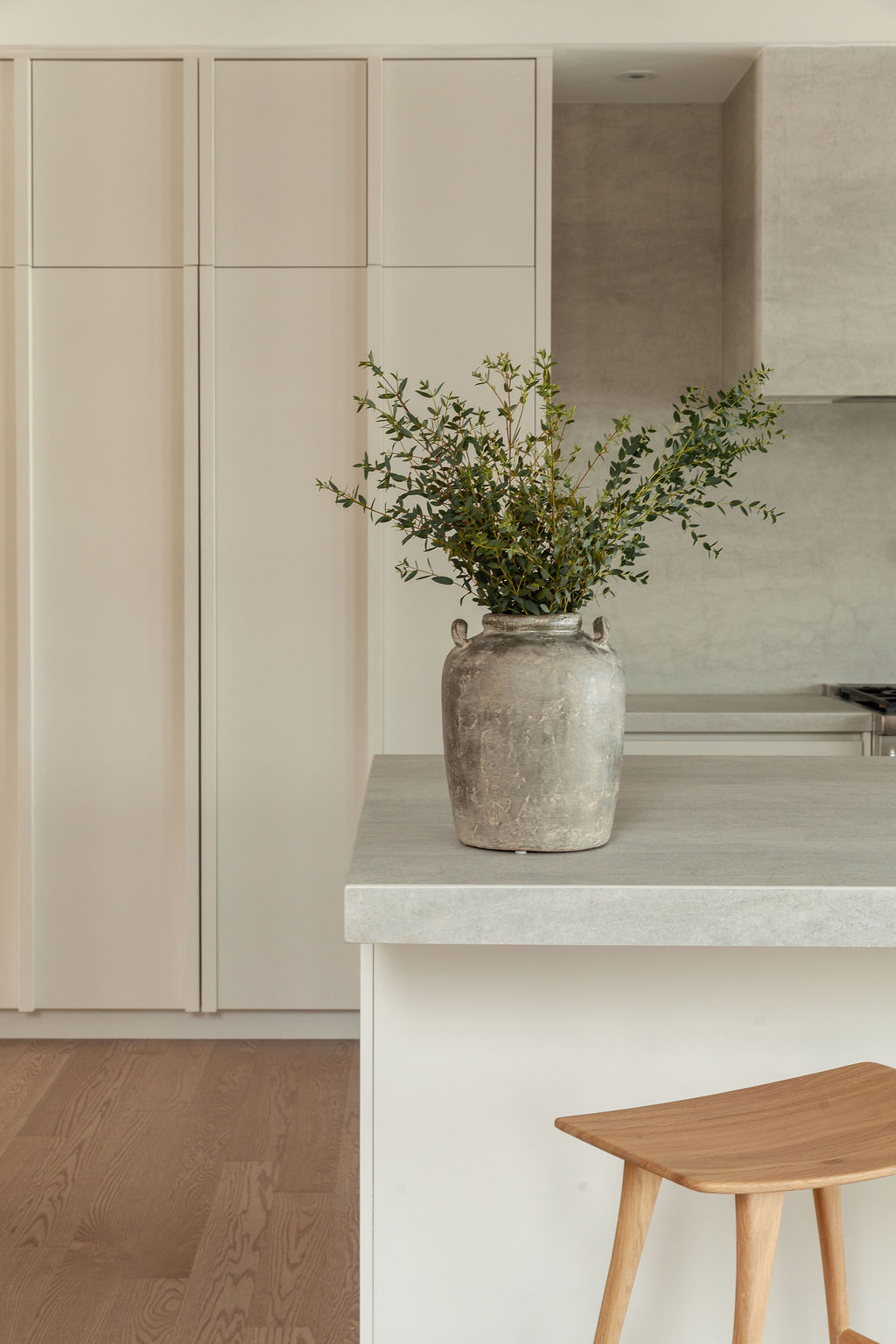 Vase en terre cuite sur le comptoir en surface minérale de la cuisine Farand, soulignant l’équilibre des matières naturelles.